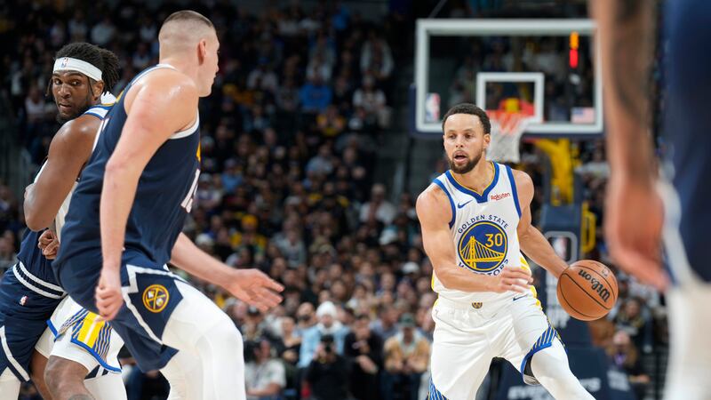 Golden State Warriors guard Stephen Curry, right, looks to drive the lane as Denver Nuggets...